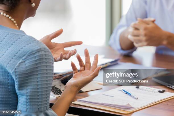 frustrated woman discusses loan with bank officer - credit union stock pictures, royalty-free photos & images