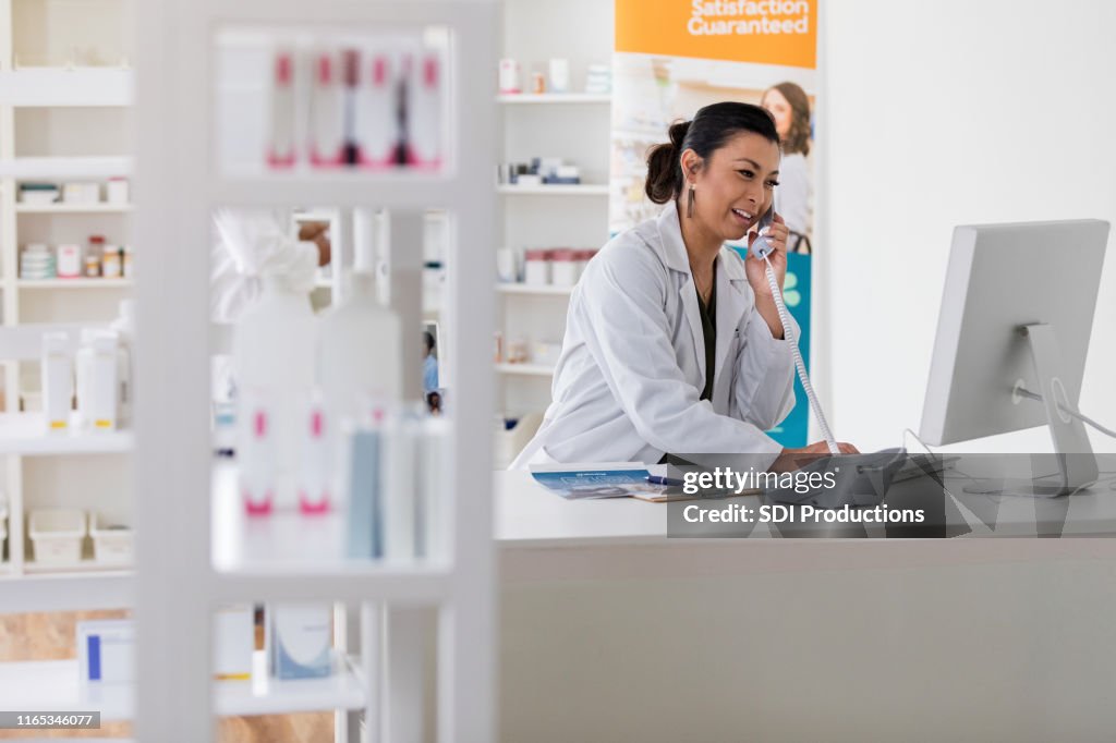 Pharmacist uses phone in pharmacy