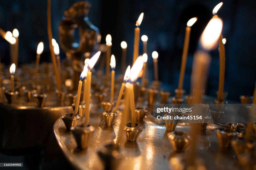 The light on candles in the church with the dark tone of background for praying to the God