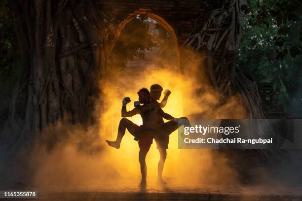 asian boxers are fighting muay thai martial arts at thai temples. muay thai is a fight and culture of thailand. - muaythai boxing stock pictures, royalty-free photos & images