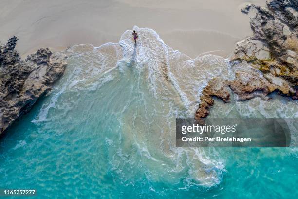 aerial view of a woman walking out of the water_little exuma_exuma_bahamas - costa caratteristica costiera foto e immagini stock