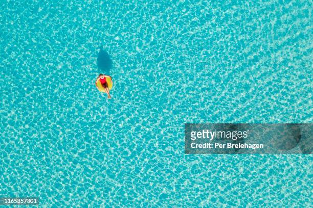 a girl relaxing in an inner tube_little exuma_bahamas. - one per stock pictures, royalty-free photos & images