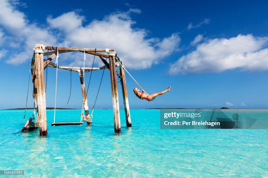 A girl swinging at Cocoplum Beach_Exuma_Bahamas.