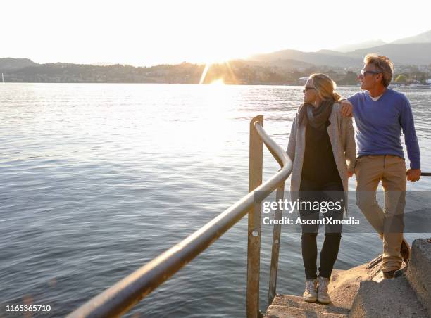 paar blick über see bei sonnenaufgang vom seesteg - blonde attraction stock-fotos und bilder