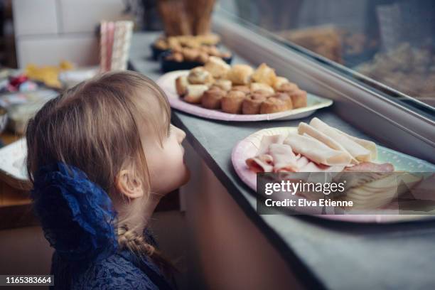 girl (6-7) looking with anticipation at buffet food at a party - pork pie stock pictures, royalty-free photos & images