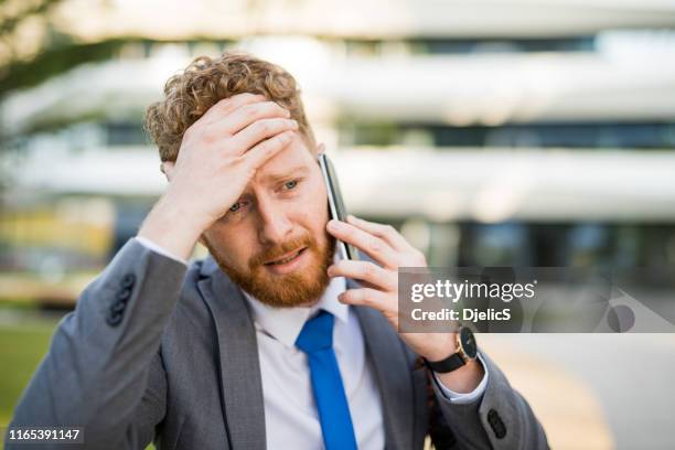 giovane uomo d'affari al telefono che incontra una crisi. - facing fear foto e immagini stock