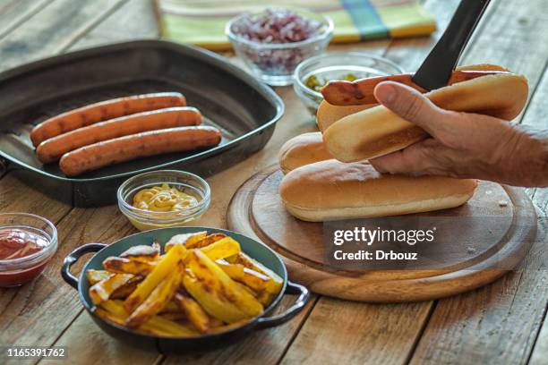 hot dog preparing, sausage and hotdog bun, close-up - breakfast sausage stock pictures, royalty-free photos & images