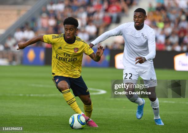 Reiss Nelson of Arsenal takes on Jeff Reine-Adelaide of Angers during the pre-season friendly match between Angers and Arsenal at Stade Raymond Kopa...