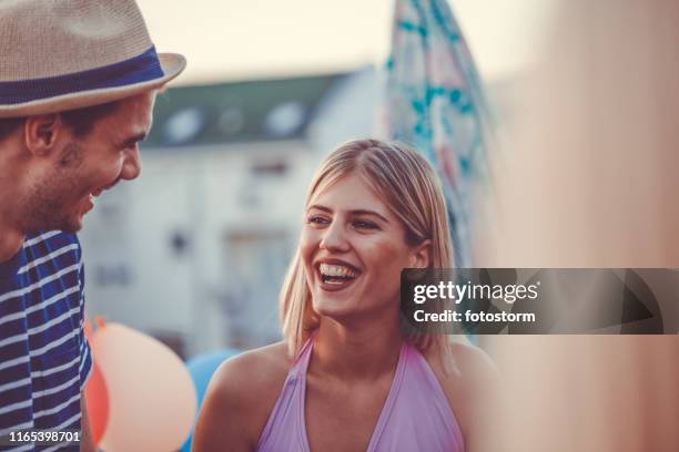 lovely young couple at roof party - singles stock pictures, royalty-free photos & images