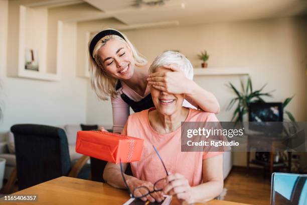 mädchen bedeckt mutter augen und geben ihr geschenk - surprised mum stock-fotos und bilder