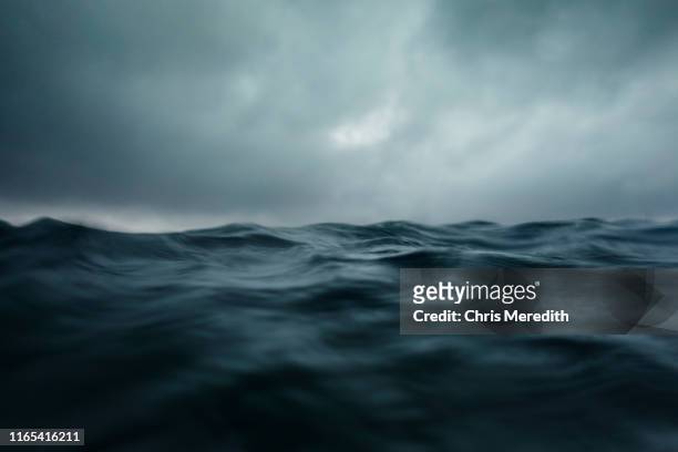 dramatic seascape with ocean wave and dark sky - cielo variabile foto e immagini stock