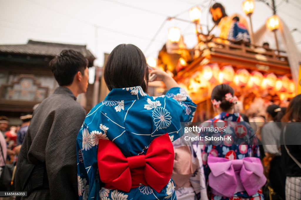 Jong paar in yukata het nemen van foto's van matsuri Parade