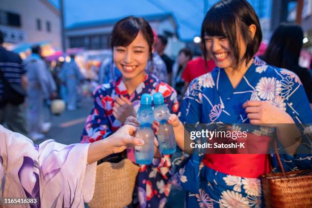 junge frauen in yukata toasten mit soda - yukata kimono stock-fotos und bilder