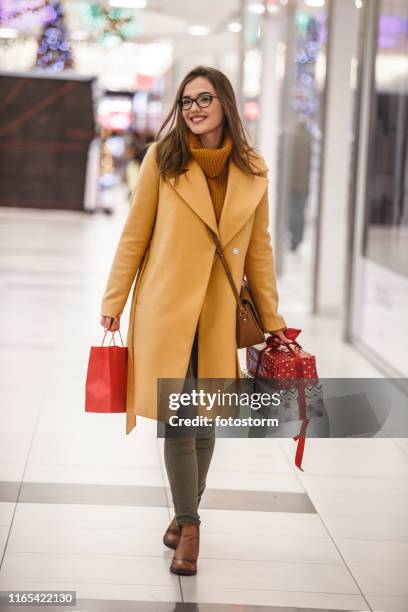 joyful woman carrying shopping bags and gift boxes - january shopping stock pictures, royalty-free photos & images