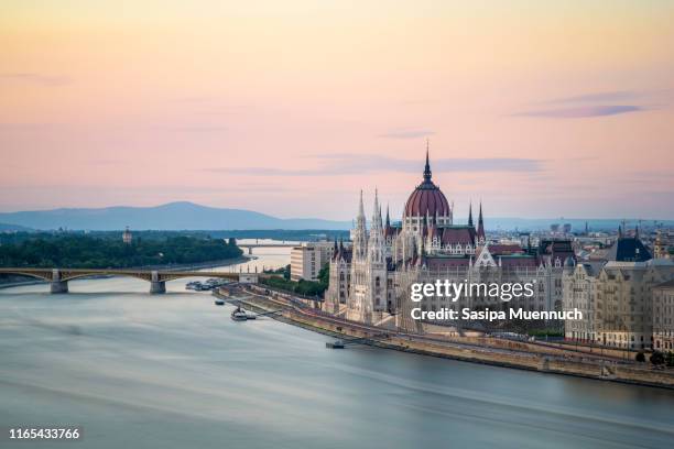 the hungarian parliament building on the banks of the danube at dawn - danube river stock-fotos und bilder