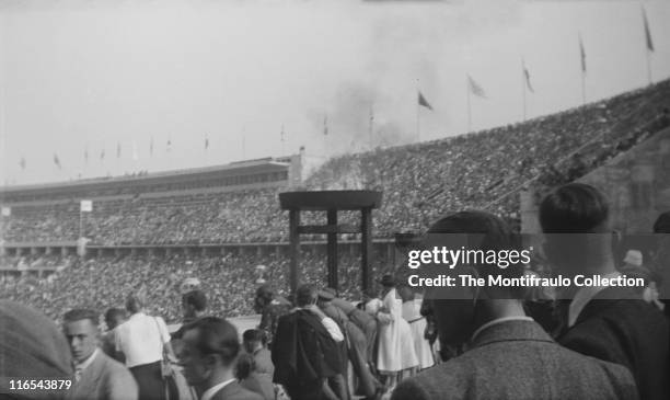 Huge crowds inside the 1936 Olympic stadium in Berlin, Germany waiting to watch the Summer Olympics, officially known as the Games of the XI...