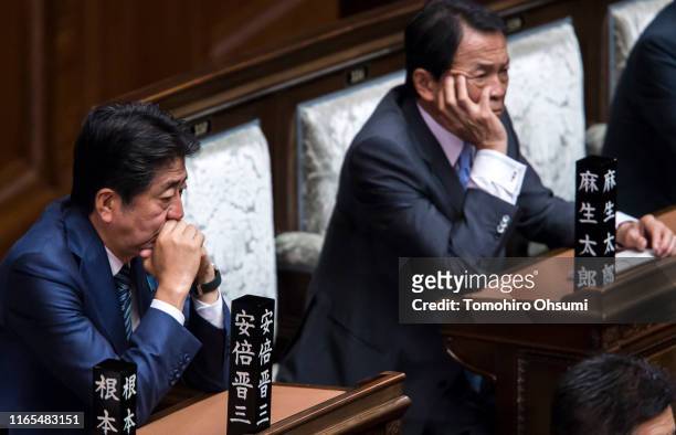 Japan's Prime Minister Shinzo Abe and Deputy Prime Minister and Finance Minister Taro Aso attend a plenary session at the lower house of the...
