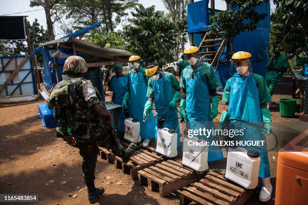 United Nations peacekeeper has his shoes cleaned with a chlorine solution before leaving an Ebola treatment centre in Mangina, North Kivu province,...