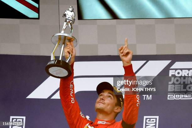 Winner Ferrari's Monegasque driver Charles Leclerc holds his trophy and gestures towards the sky in tribute to late French driver Anthoine Hubert on...