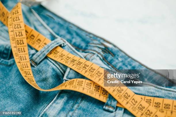 jeans denim and measure tape.top view - centimeter fotografías e imágenes de stock