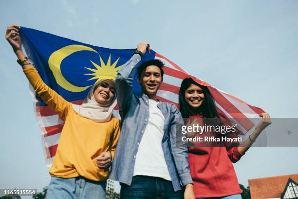 junger erwachsener feiert malaysias unabhängigkeitstag - malaysia stock-fotos und bilder