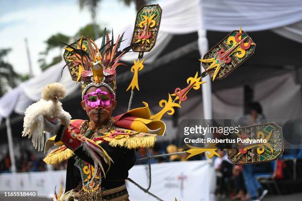 Model performs with a chicken during Pets Carnival as part of the 18th Jember Fashion Carnival 2019 on August 01, 2019 in Jember, Indonesia. The 18th...