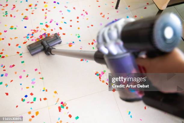 cleaning home floor with vacuum after party with confetti. - cleaning up after party stock pictures, royalty-free photos & images