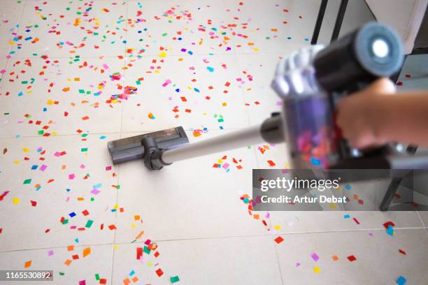 cleaning home floor with vacuum after party with confetti. - saugen mund benutzen stock-fotos und bilder