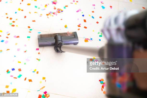cleaning home floor with vacuum after party with confetti. - messy house after party stock pictures, royalty-free photos & images