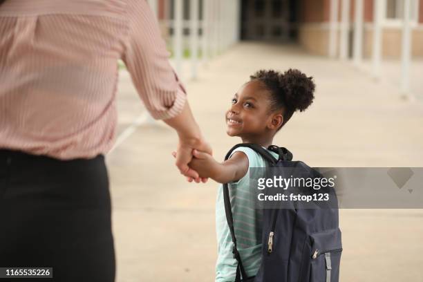 elementary, afroamerikanische mädchen mit mama am ersten tag der schule. - erster schultag stock-fotos und bilder