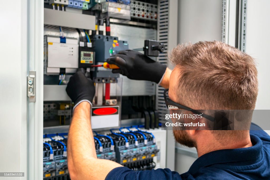 Electrician working at electric panel