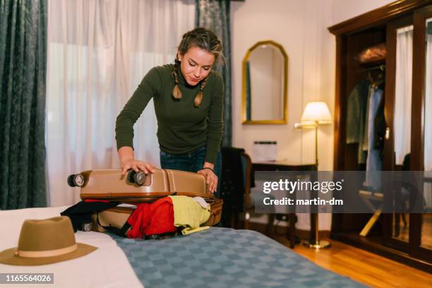 ragazza che chiude la valigia in camera d'albergo - suitcase close foto e immagini stock