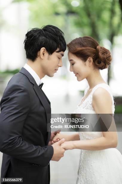 bride and groom holding hands - 結婚式 日本 ストックフォトと画像