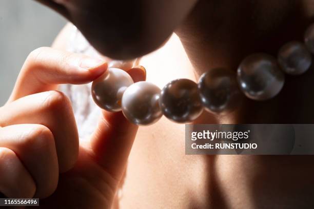 close up of bride holding pearl necklace - collana foto e immagini stock