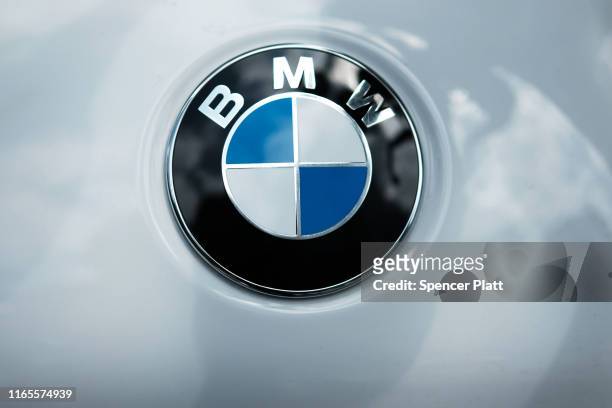 Logo is displayed on a vehicle in Manhattan on August 01, 2019 in New York City. Blaming slowing sales in the U.S., China and Europe, BMW announced...