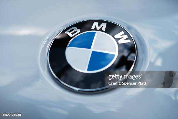 Logo is displayed on a vehicle in Manhattan on August 01, 2019 in New York City. Blaming slowing sales in the U.S., China and Europe, BMW announced...