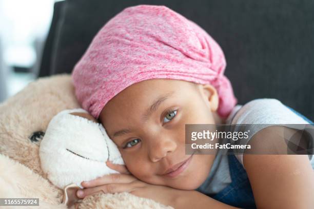 happy girl with cancer hugs teddy bear - childhood cancer stock pictures, royalty-free photos & images