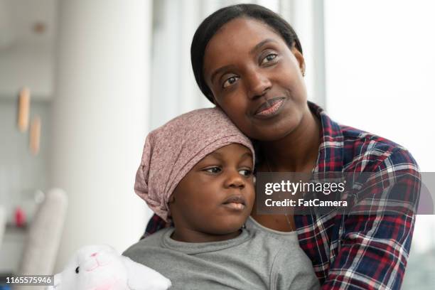 supportive mother holds child with cancer - childhood cancer stock pictures, royalty-free photos & images
