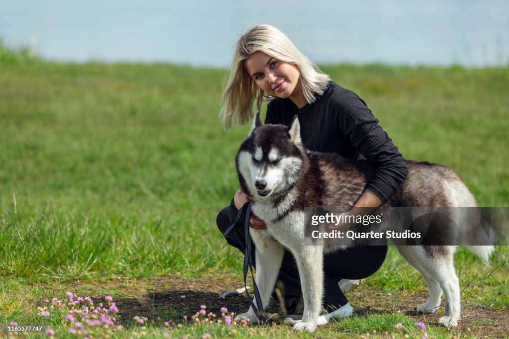 Siberian Husky With Blonde Woman In The Outdoors High-Res Stock