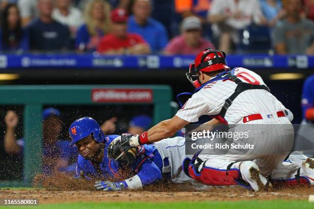 Rajai Davis of the New York Mets is tagged out by catcher J.T. Realmuto of the Philadelphia Phillies as he attempted to score on a fielder's choice...