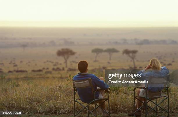 paar ontspannen in fauteuils op de savanne - safari stockfoto's en -beelden