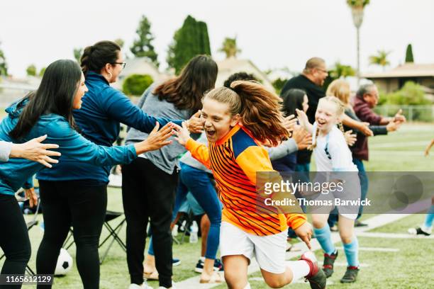 young female soccer goalie high fiving parents on sidelines after soccer game - calcio sport foto e immagini stock