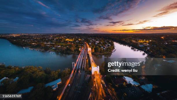 a tranquil high angle view of brisbane river at walter taylor bridge, albert bridge, indooroopilly railway bridge and jack pesch bridge at a cloudy dusk - brisbane transport stock pictures, royalty-free photos & images