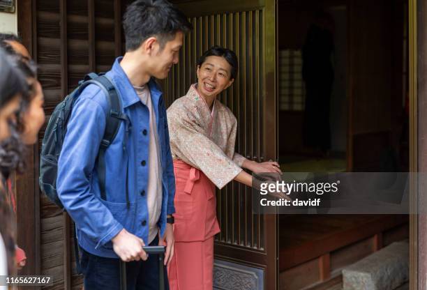 traditionellt klädd japansk kvinna bugande till besökare till hennes värdshus - buga bildbanksfoton och bilder