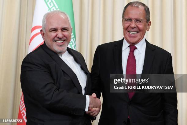 Russian Foreign Minister Sergei Lavrov and his Iranian counterpart Mohammad Javad Zarif shake hands following a meeting in Moscow on September 2,...