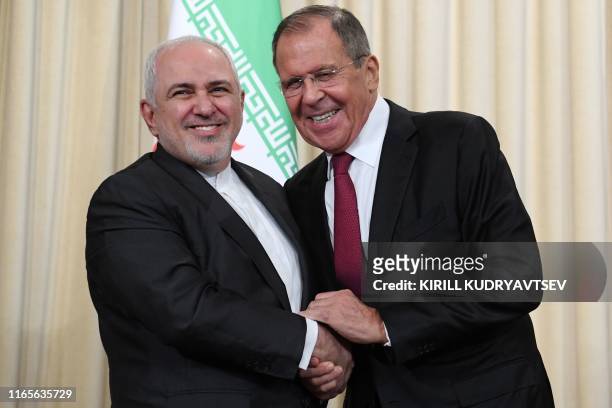 Russian Foreign Minister Sergei Lavrov and his Iranian counterpart Mohammad Javad Zarif shake hands following a meeting in Moscow on September 2,...