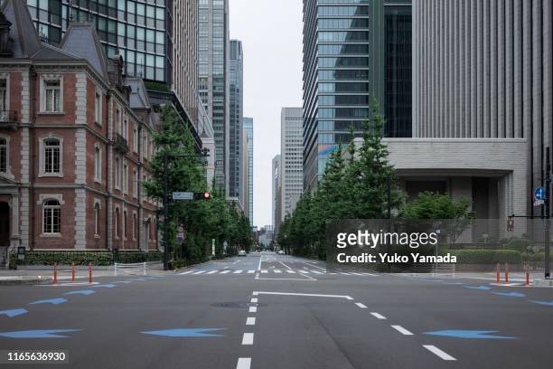 road amidst high-rise building during morning - empty city foto e immagini stock