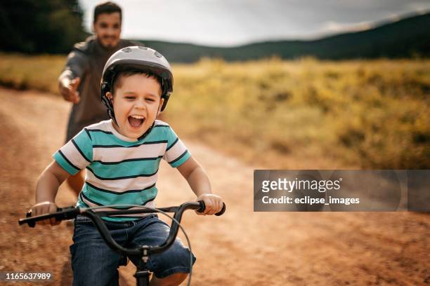 you are ready to go alone - father helping son wearing helmet stock pictures, royalty-free photos & images
