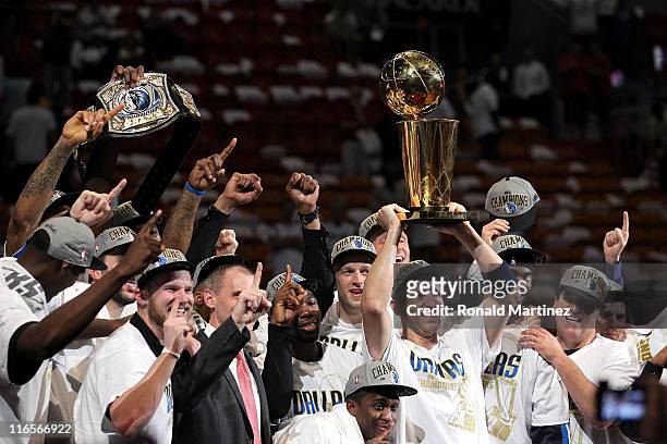 Jason Kidd of the Dallas Mavericks holds up the Larry O'Brien Championship trophy as he celebrates with his teammates and team owner Mark Cuban after...
