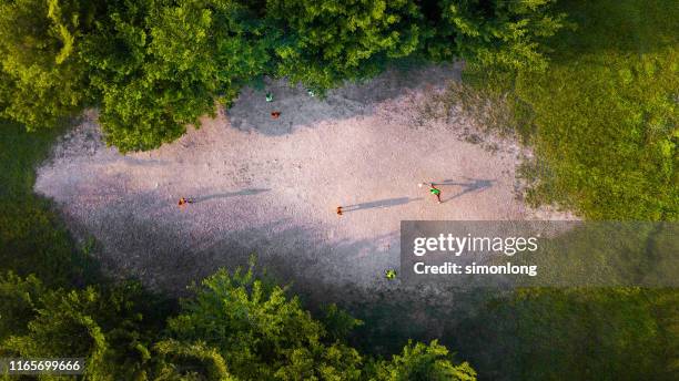 arial view of boys playing football - people above park stock pictures, royalty-free photos & images